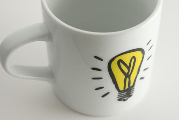 White mug with white background. Idea symbol is on the mug.